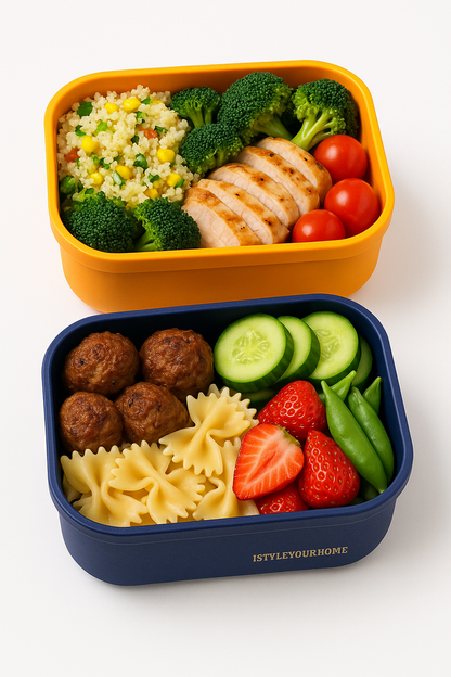 Two bento boxes with food including rice, vegetables, and meatballs on a white background.